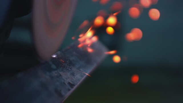 Macro: Worker cutting steel with an angle grinder in a metal workshop, bright sparks flying. Industrial tool, heat, and precision in construction and manufacturing