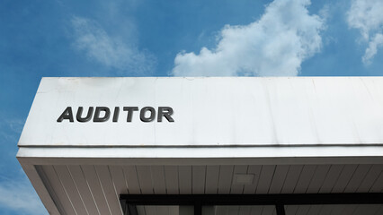 Auditor word sign displayed on building under clear blue sky, representing financial review, accounting, inspection, and professional oversight services