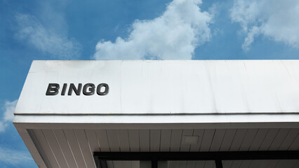 Bingo word sign displayed on building under clear blue sky, representing games, entertainment, social activity, and recreational venues