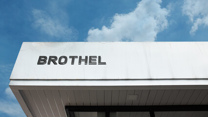 Brothel word sign displayed on building under clear blue sky, representing regulated premises, nightlife zones, district signage, and urban environments