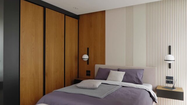 Modern minimalist bedroom interior with upholstered bed, wooden wall panels, soft neutral textiles, floating nightstands and ambient lighting captured as a vertical downward video frame