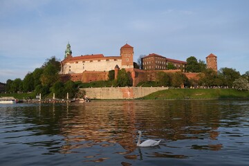 Obraz premium Historic Wawel Castle complex and Vistula River with beautiful reflections in foreground in afternoon sunlight. Krakow, Poland