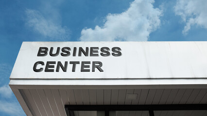 A business center word sign displayed on a building against a clear blue sky, showing clean signage and a modern professional exterior