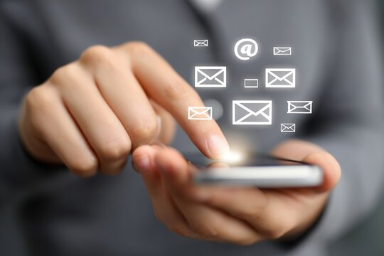 Close-up of a hand interacting with a smartphone, sending messages, with digital icons representing communication, showcasing modern technology and connectivity in everyday life