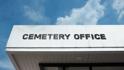 Obraz premium Cemetery Office word sign displayed on a building under a clear blue sky, representing burial services, memorial administration, grave management, and funeral facilities