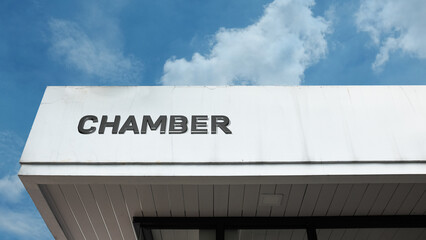 Chamber word sign displayed on a building under a clear blue sky, representing official meeting space, administrative office, corporate functions, and institutional facilities