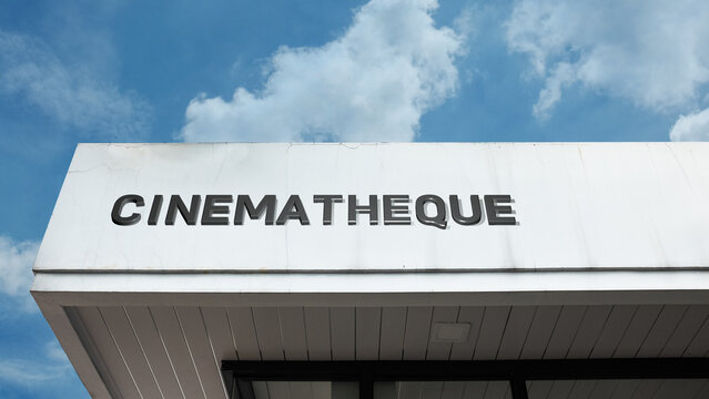 Cinematheque word sign displayed on a building under a clear blue sky, representing film archive, movie screenings, cultural cinema, and entertainment facilities