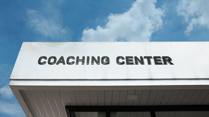 Obraz premium Coaching Center word sign displayed on a building under a clear blue sky, representing education, learning, training, student development, and academic support facilities