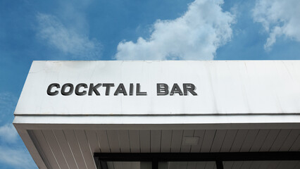 Cocktail Bar word sign displayed on a building under a clear blue sky, representing nightlife, drinks, socializing, leisure, and entertainment facilities