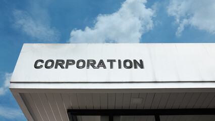 Naklejka premium Corporation word sign displayed on a building under a clear blue sky, representing business, corporate structure, enterprise, management, leadership, and professional services