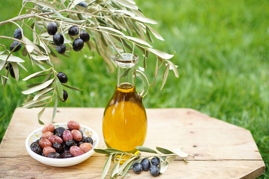 Olive oil and olives on wooden table