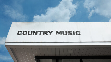 Country Music word sign displayed on a building under a clear blue sky, representing musical performance, entertainment, culture, instruments, and live shows
