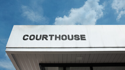 Courthouse word sign displayed on a building under a clear blue sky, representing legal services, judiciary, law enforcement, public administration, and government facilities