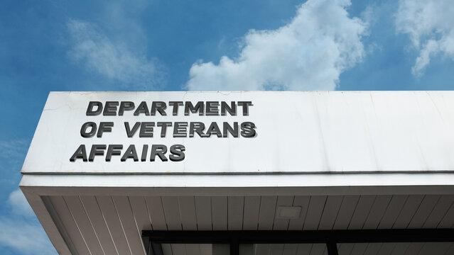 Department of Veterans Affairs word sign on a building under a clear blue sky, representing military veterans' services, healthcare, government policy, and support programs