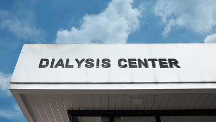 Obraz premium Dialysis Center word sign displayed on a building under a clear blue sky, symbolizing kidney care, medical treatment, and health services