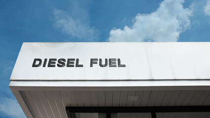 Diesel Fuel word sign displayed on a building under a clear blue sky, symbolizing energy, fuel, power, and transportation services.