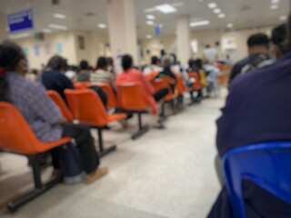 Many patients are sitting and waiting to see a doctor in the hospital.