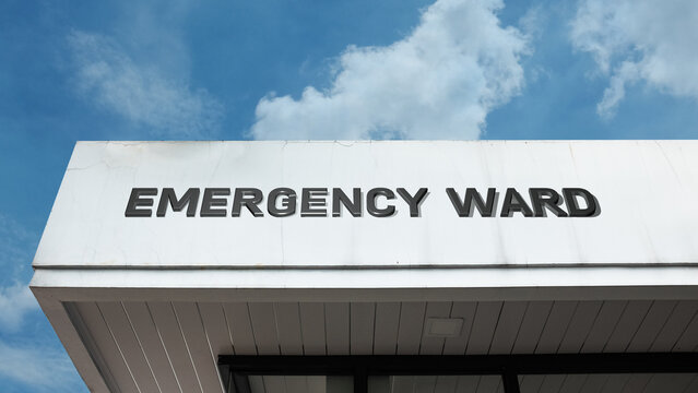Emergency Ward sign displayed on a building against a clear blue sky, symbolizing critical care, immediate treatment, hospital services, urgent medical aid, and rapid response unit