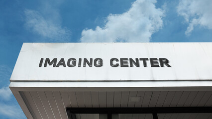 Obraz premium Imaging Center sign displayed on a building against a clear blue sky, symbolizing medical diagnostics, radiology services, scanning, and healthcare