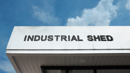 Obraz premium Industrial Shed sign on a building against a clear blue sky, symbolizing manufacturing storage, warehouse facility, commercial utility, and metal