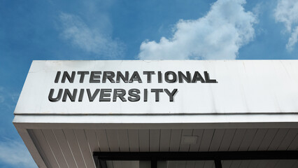 Obraz premium International University sign on a building against a clear blue sky, symbolizing higher education, global studies, diverse students, research, and degrees