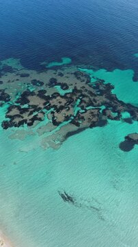 Drone view of Maladroxia&rsquo;s clear turquoise sea, sandy shoreline, and coastal houses