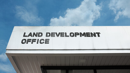 Obraz premium Land Development Office sign on a building against a clear blue sky, symbolizing urban planning, property management, zoning regulation, infrastructure, and growth