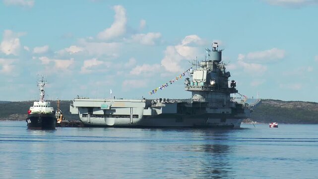 SEVEROMORSK, RUSSIA - JULY 28, 2013: The old Russian aircraft carrier ADMIRAL KUZNETSOV is anchored in the Kola Bay on a sunny summer day. 
