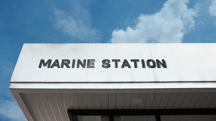Obraz premium Marine Station sign on a building against a clear blue sky, symbolizing research facility, oceanography, coastal service, nautical science, and habitat study
