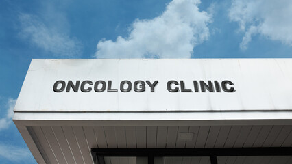 Obraz premium Oncology Clinic word signage on a specialized medical building under a blue sky, symbolizing cancer treatment, healthcare, clinical research, and hope