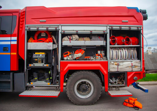 Fire truck equipment storage showing firefighting gear, hoses, and tools at an emergency response site
