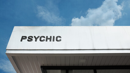 Psychic word signage on a commercial or business building under a blue sky, symbolizing clairvoyance, fortune telling, spiritual guidance, mystery, and esoteric services