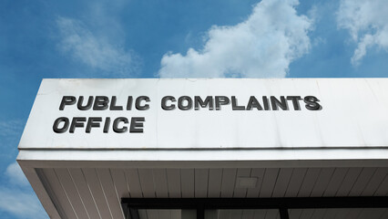 Obraz premium Public Complaints Office word signage on a government building under a blue sky, symbolizing accountability, civic service, grievances, resolution, and citizen advocacy