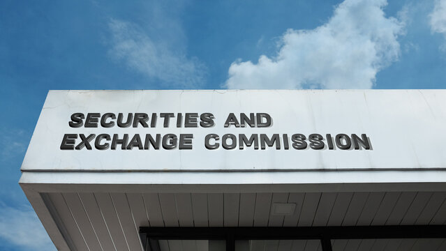 Securities and Exchange Commission word signage on a government or financial building under a blue sky, symbolizing market regulation, corporate oversight, investor protection, and economic authority