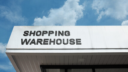 Shopping Warehouse word signage on a large retail or industrial building under a blue sky, symbolizing bulk purchasing, discount retail, storage, supply, logistics, and consumer big-box store