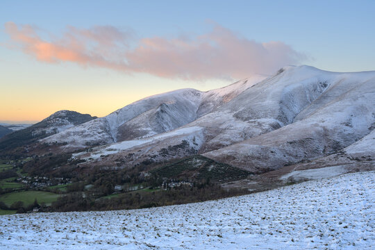 Dramatic winter view of Skiddaw mountain covered in snow on a cold winter evening up Latrigg in The Lake District, UK.