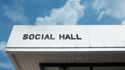 Social Hall word signage on a community or public building under a blue sky, symbolizing meetings, gatherings, events, civic functions, association, recreation, and local assembly