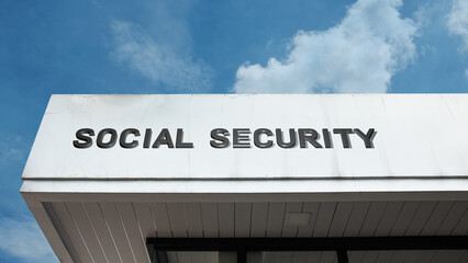 Social Security word signage on a government or public building under a blue sky, symbolizing public welfare, retirement, government aid, financial planning, citizen benefits, and insurance programs