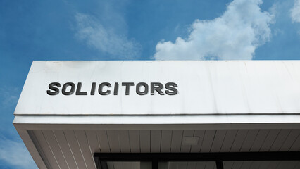 Solicitors word signage on a professional or commercial building under a blue sky, symbolizing legal practice, law firm, consultation, legal advice, barrister services, and justice administration