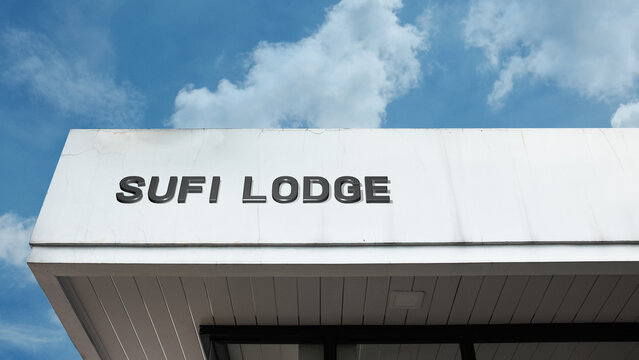 Sufi Lodge word signage on a spiritual or institutional building under a blue sky, symbolizing Islamic mysticism, retreat, spiritual practice, devotion, community, worship, and theological education