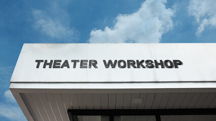 Obraz premium Theater Workshop word signage on a cultural or educational building under a blue sky, symbolizing performing arts training, acting classes, creative development, stage craft, and rehearsal space