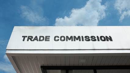 Trade Commission word signage on a government or regulatory building under a blue sky, symbolizing commercial law, antitrust, consumer protection, fair business practices, and official oversight