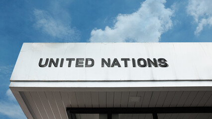Obraz premium United Nations word signage on a global diplomatic building under a blue sky, symbolizing international relations, cooperation, peace, diplomacy, and global governance