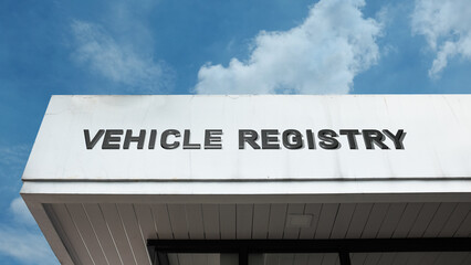 Obraz premium Vehicle Registry word signage on a government building under a blue sky, symbolizing official records, licensing, regulatory compliance, public administration, and transportation law
