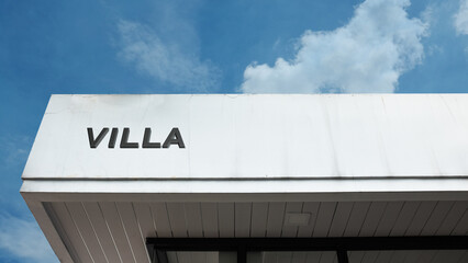 Villa word signage on a luxury residence building under a blue sky, symbolizing upscale accommodation, travel, real estate, vacation rental, retreat, and exclusivity