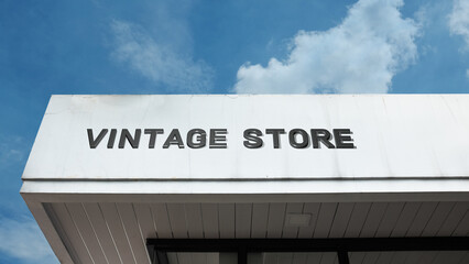 Vintage Store word signage on a retail building under a blue sky, symbolizing retro style, secondhand shopping, nostalgia, antique items, collectibles, and throwback fashion