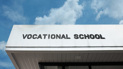 Vocational School word signage on an educational building under a blue sky, symbolizing career training, practical skills, technical education, job readiness, and trades