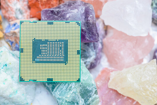 Semiconductor chip resting on raw minerals. Represents the rising strategic importance of rare-earth elements, global tech supply risk, and US-China resource competition.