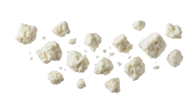 Scattered feta crumbles on a clean surface present a visually interesting texture and pattern composition with a focus on food delicacy