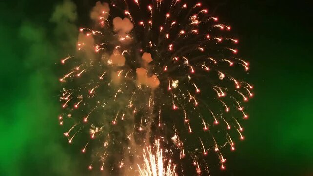 Vibrant red fireworks explosion against a dark night sky creates a festive celebration atmosphere for events